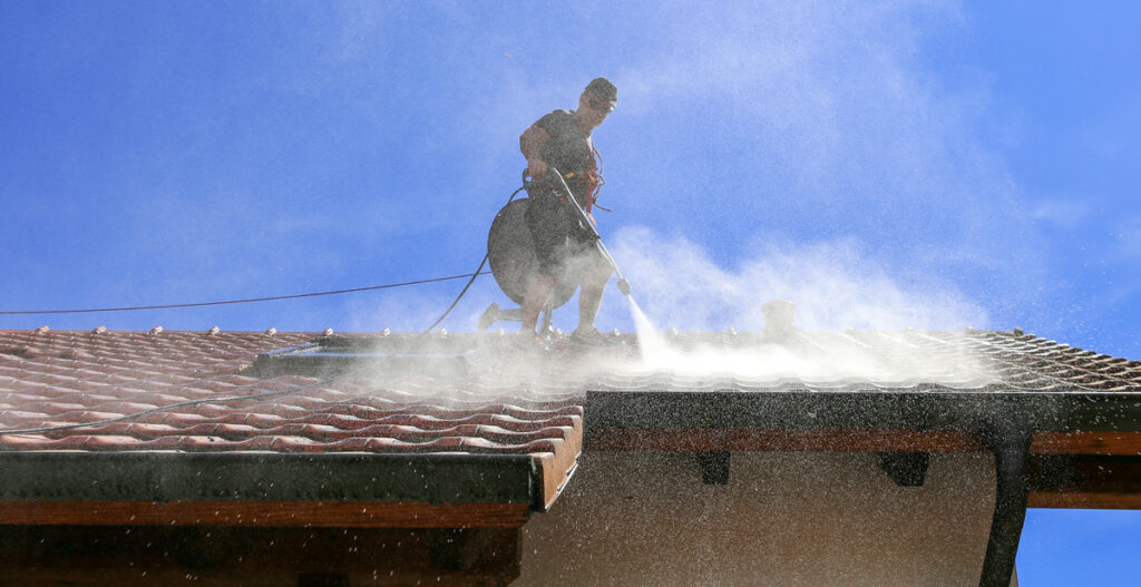 Worker using a roller to paint a ceiling.
