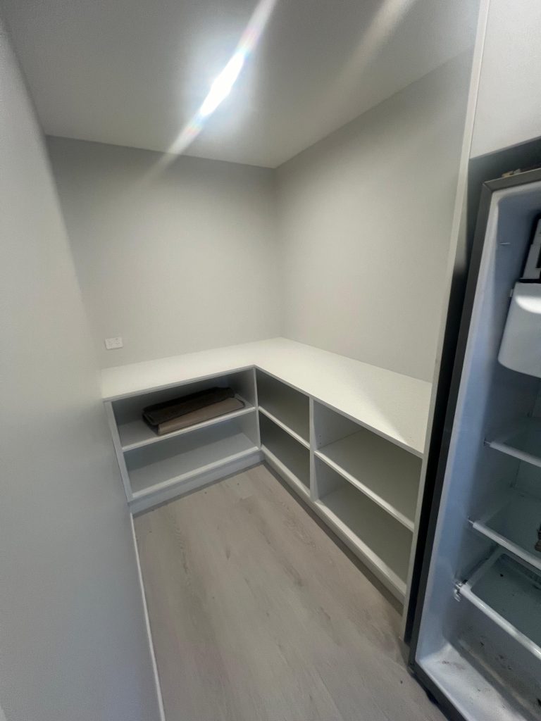 a room with shelves and a refrigerator